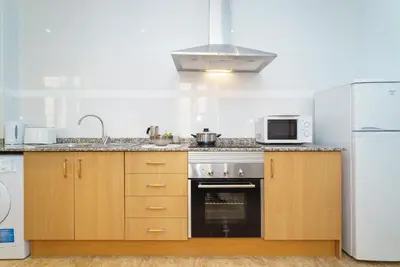 a kitchen with a stove and a microwave at Apartamentos Mercat in Valencia