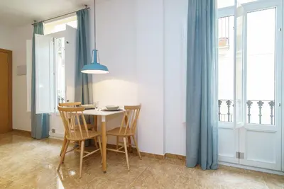 a dining room with a table and chairs and a window at Apartamentos Mercat in Valencia