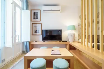 a living room with a table and blue stools at Apartamentos Mercat in Valencia
