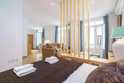 a bedroom with a bed and a living room at Apartamentos Mercat in Valencia