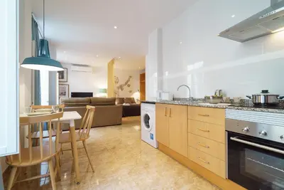 a kitchen and living room with a table and chairs at Apartamentos Mercat in Valencia