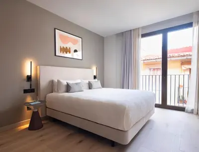 a bedroom with a large bed and a large window at Numa Valencia El Carmen in Valencia