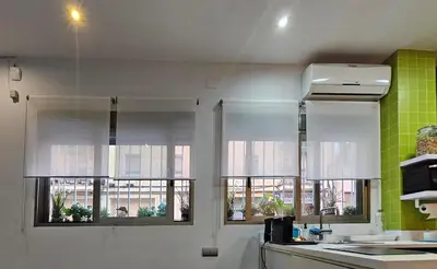 a kitchen with two windows with white curtains at Estudio Loft área Ruzafa in Valencia