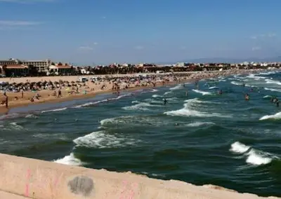 a beach with a bunch of people in the water at Estudio Loft área Ruzafa in Valencia