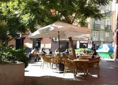 a group of people sitting at tables under an umbrella at Estudio Loft área Ruzafa in Valencia