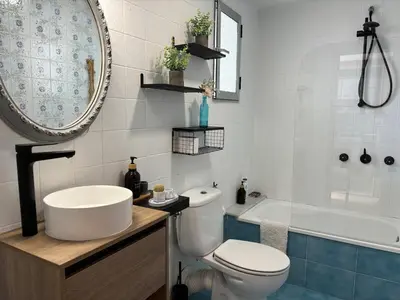 a bathroom with a toilet and a sink and a tub at Parking Privado l Terraza Relajante Junto Al Mar in Tavernes de Valldigna
