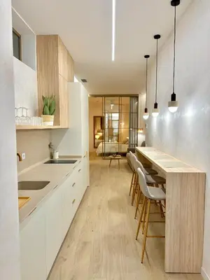 a kitchen with white cabinets and a wooden table at Anelsa Suites Serranos 3 in Valencia