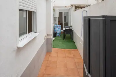 an alley with a table and a chair in a building at Cómodo apartamento cerca del metro y de la feria Valencia in Paterna