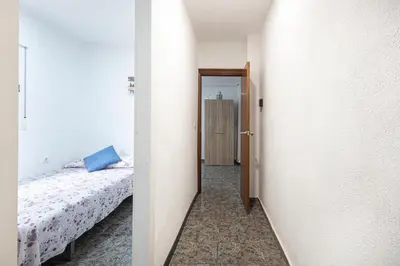 a bedroom with a bed and a door to a hallway at Cómodo apartamento cerca del metro y de la feria Valencia in Paterna