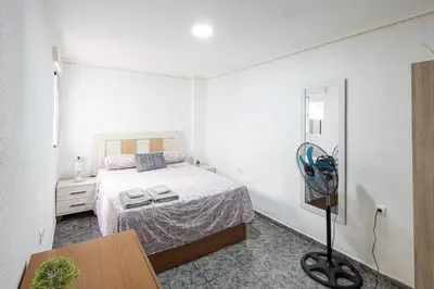 a bedroom with a bed and a fan in it at Cómodo apartamento cerca del metro y de la feria Valencia in Paterna
