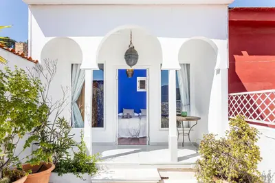 a white house with blue walls and a patio at Romantic Mediterranean Riad in Tavernes de Valldigna