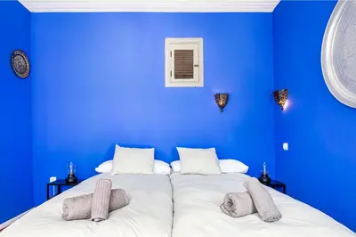 a blue room with a bed with two pillows at Romantic Mediterranean Riad in Tavernes de Valldigna
