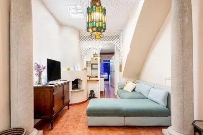 a living room with a couch and a tv at Romantic Mediterranean Riad in Tavernes de Valldigna