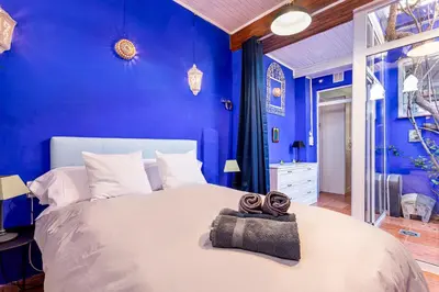 a blue bedroom with a large bed with two towels on it at Romantic Mediterranean Riad in Tavernes de Valldigna