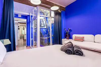 a blue bedroom with a white bed and a window at Romantic Mediterranean Riad in Tavernes de Valldigna