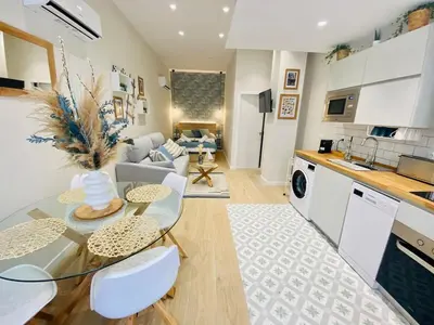 a living room with a table and a kitchen at Beautiful modern loft 1km from the sea in Valencia in Valencia