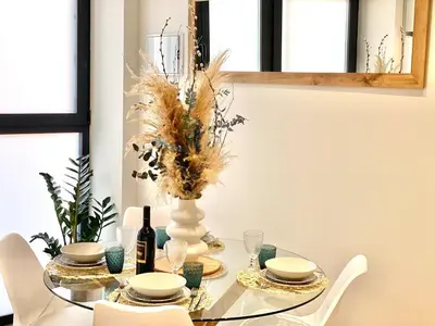 a dining room table with a vase and plates and chairs at Beautiful modern loft 1km from the sea in Valencia in Valencia