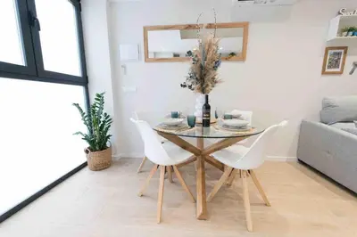 a dining room with a table and white chairs at Beautiful modern loft 1km from the sea in Valencia in Valencia