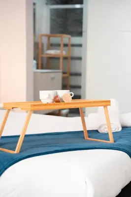 a wooden tray sitting on top of a bed at Apartamento a 7 minutos de la playa y cerca de la estación de autobús in Valencia