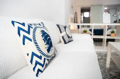 a white couch with a baseball pillow on it at Apartamento a 7 minutos de la playa y cerca de la estación de autobús in Valencia