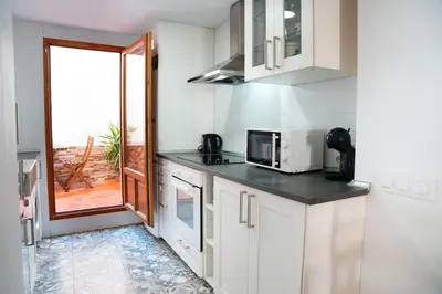a kitchen with white cabinets and a microwave at Apartamento a 7 minutos de la playa y cerca de la estación de autobús in Valencia