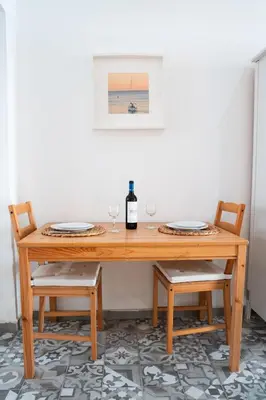 a wooden table with two chairs and a bottle of wine at Apartamento a 7 minutos de la playa y cerca de la estación de autobús in Valencia