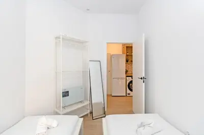 a white room with two beds and a mirror at GuestReady - Cozy flat in Valencia in Valencia