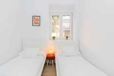 two beds in a white room with a candle on a table at GuestReady - Cozy flat in Valencia in Valencia