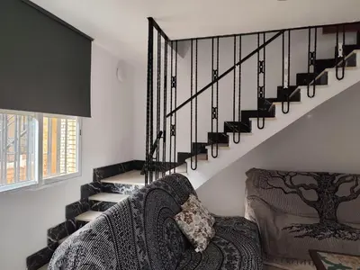 a living room with a couch and a spiral staircase at La Casa de los Alemanes in Gaibiel