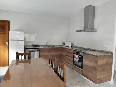 a kitchen with a wooden table and a counter top at La Casa de los Alemanes in Gaibiel