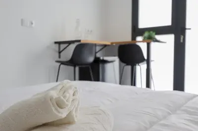 a bed with a towel on it with a table and chairs at La plata 59 in Valencia