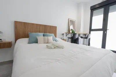 a large white bed with two towels on it at La plata 59 in Valencia