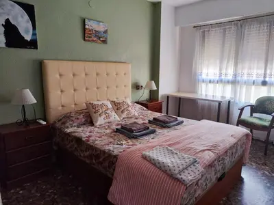 a bedroom with a bed and a chair and a window at Plaza Mare Nostrum 5 min playa in Puerto de Sagunto