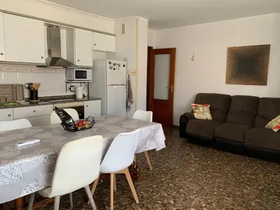 a kitchen and living room with a table and a couch at Plaza Mare Nostrum 5 min playa in Puerto de Sagunto