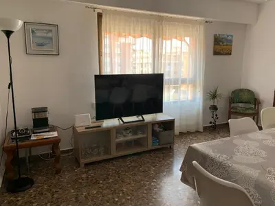 a living room with a flat screen tv on a cabinet at Plaza Mare Nostrum 5 min playa in Puerto de Sagunto