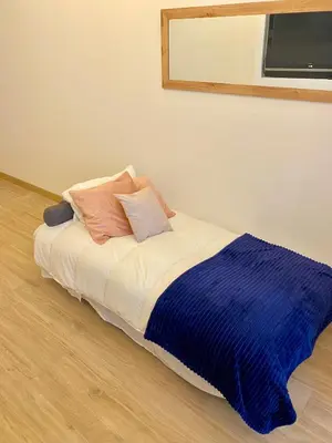 a bed with a blue blanket on top of it at Acogedor bajo en Valencia in Valencia