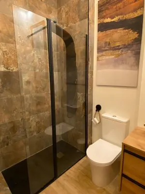 a bathroom with a toilet and a glass shower at Acogedor bajo en Valencia in Valencia