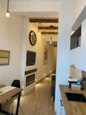 a kitchen and dining room with a clock on the wall at Acogedor bajo en Valencia in Valencia