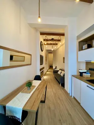 a kitchen and living room with a table and a couch at Acogedor bajo en Valencia in Valencia