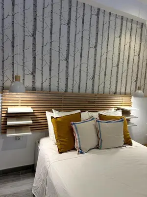 a bedroom with a bed with a wall with trees at Loft in Valencia, equipped and very well decorated in Valencia