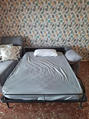 a bed sitting in a room with a wall at Arensol Playa de Cullera in Cullera