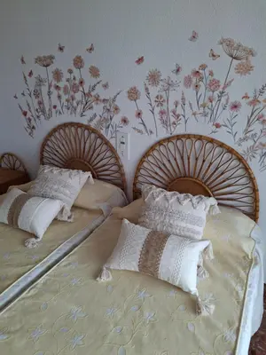 two twin beds in a bedroom with floral wallpaper at Arensol Playa de Cullera in Cullera