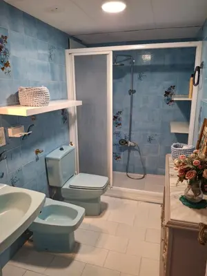 a blue bathroom with a toilet and a shower at Arensol Playa de Cullera in Cullera