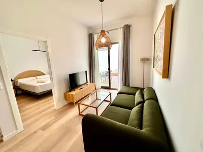 a living room with a green couch and a bedroom at Filologo Sanelo Luxury Apartaments in Valencia