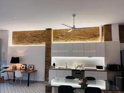a kitchen with white cabinets and a table with chairs at Family Sea & Home Cabanyal in Valencia