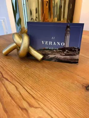 a book sitting on top of a wooden table with two cor tensticks at Family Sea & Home Cabanyal in Valencia