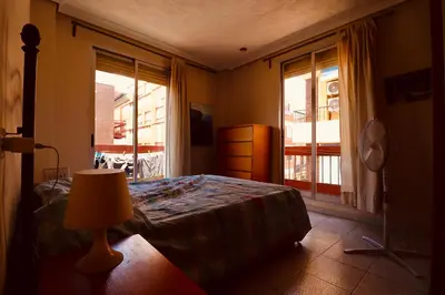 a bedroom with a bed with a lamp and a window at 2 Bed Apartment, Great Location, 500M from Beach in Valencia