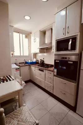 a kitchen with stainless steel appliances and a table at 2 Bed Apartment, Great Location, 500M from Beach in Valencia
