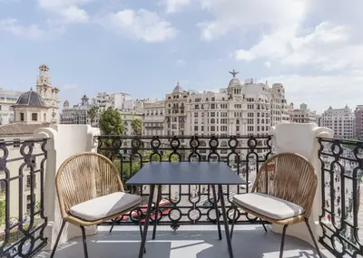a table and chairs on a balcony with a view of the city at Limehome Valencia de Xativa in Valencia