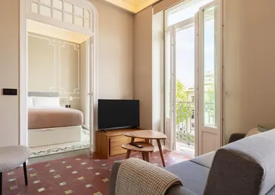 a hotel room with a bed and a tv and a balcony at Limehome Valencia de Xativa in Valencia
